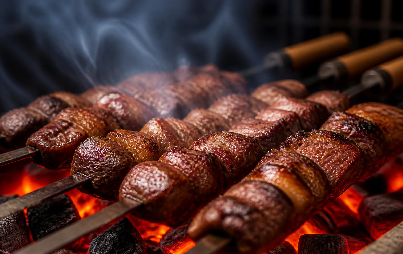 Espetinhos de carne assando na brasa em churrasqueira